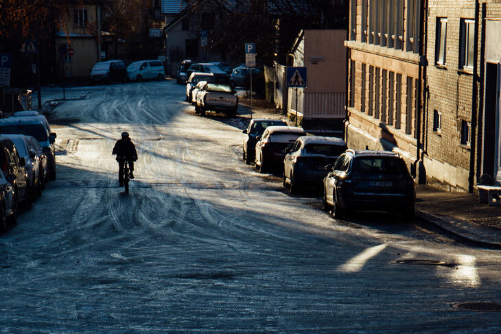 Syklist på vei nedover en vinterlig gate.